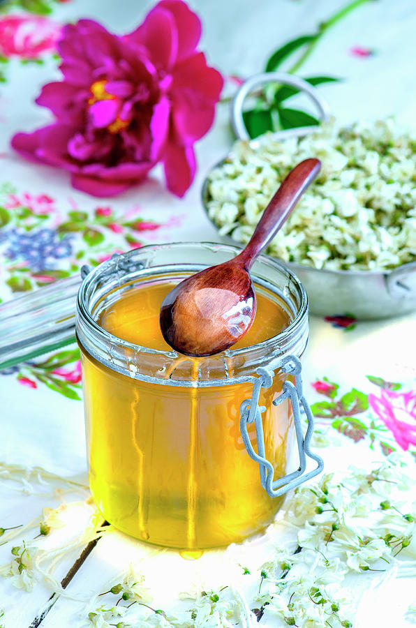 Honey In A Glass Jar With A Wooden Spoon Photograph by Gorobina