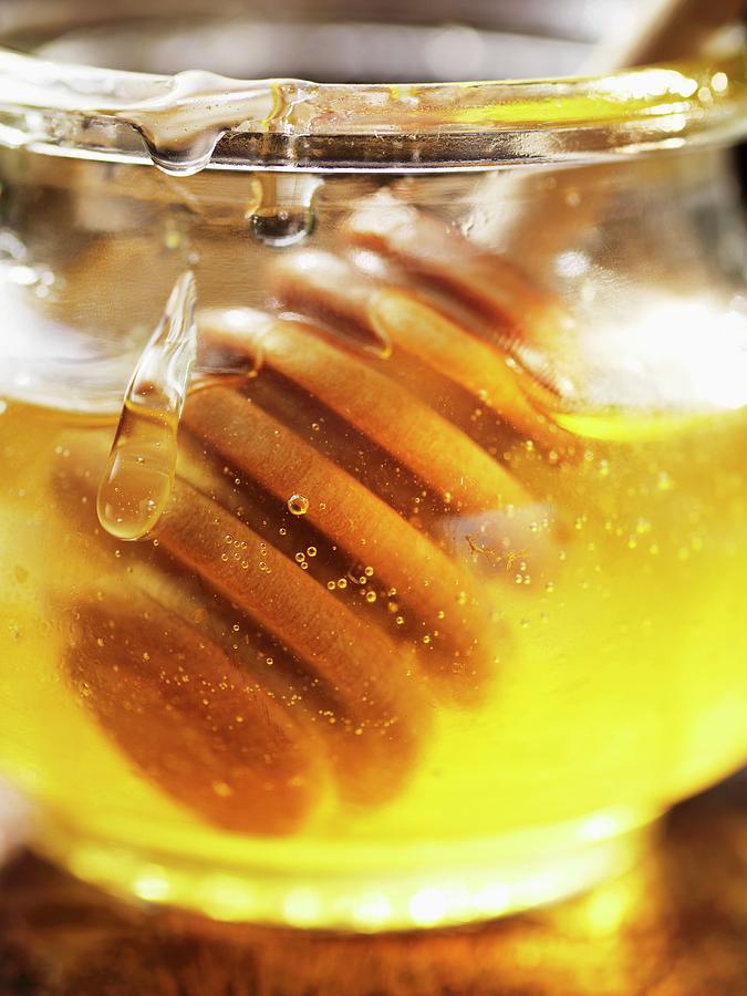 Honey In A Jar With A Honey Spoon close-up Photograph by Foodcollection