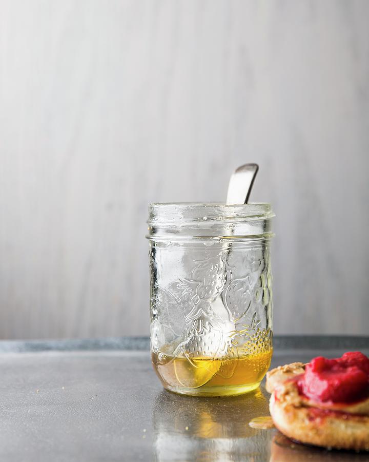Honey In A Jar With A Spoon And An English Muffin With Raspberry Jam Photograph by Keller & Keller Photography