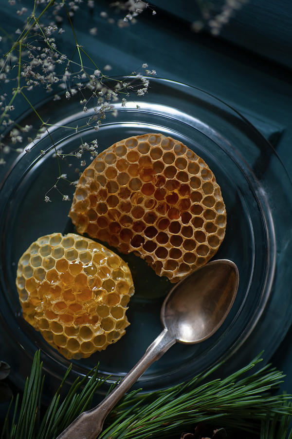 Honeycomb Oozing Honey On Glass Plate With Silver Spoon Photograph by Alicja Koll