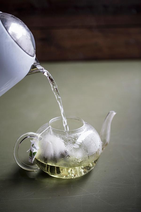 Hot Water Being Poured Into A Teapot With Tea Bags Photograph by Sneh Roy