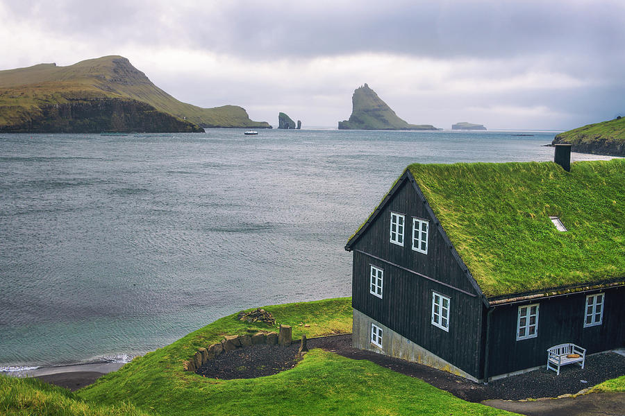 House on the coast of Faroe Islands with Drangarnir sea stack in the ...
