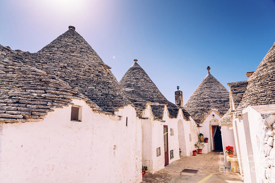 Houses of the tourist and famous Italian city of Alberobello, with its typical white walls  trulli Photograph by Joaquin Corbalan