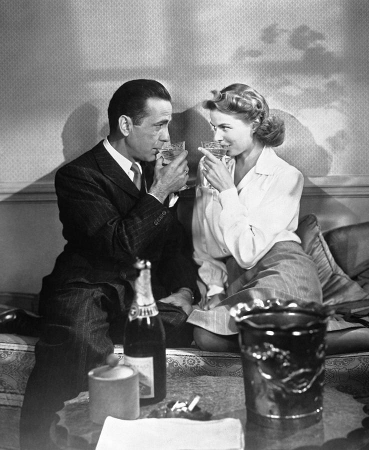 Casablanca Movie Photograph - Humohrey Bogart And Ingrid Bergman Toasting With Drinks In Hand In casablanca by Globe Photos