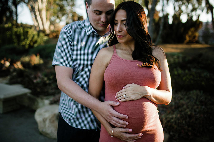 Husband Touching Pregnant Wife's Stomach While Standing In Park ...