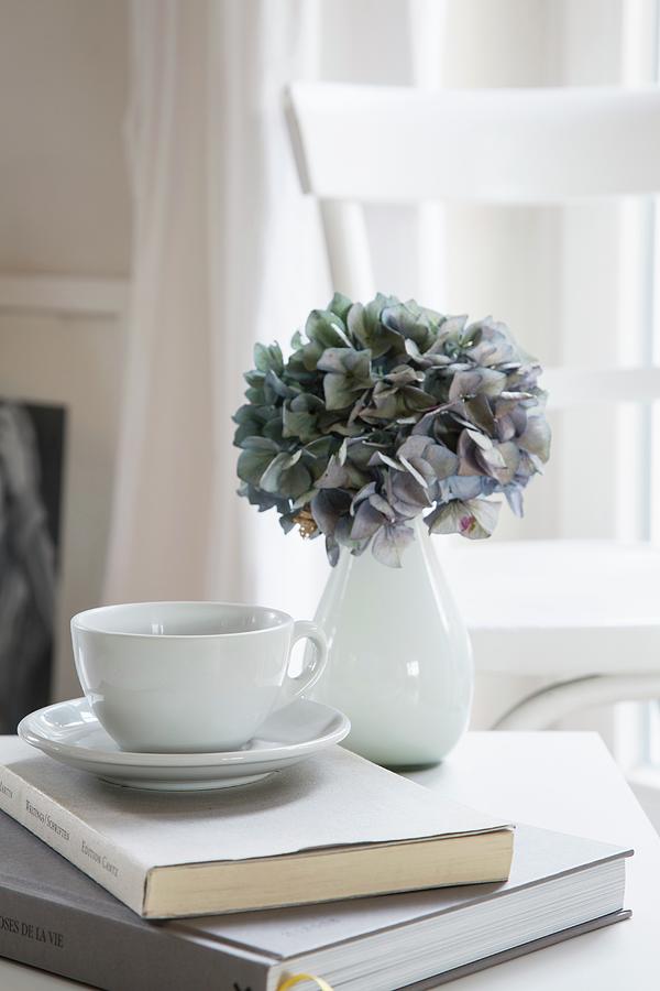 Hydrangea In White Vase And Teacup On Book Photograph by Catja Vedder