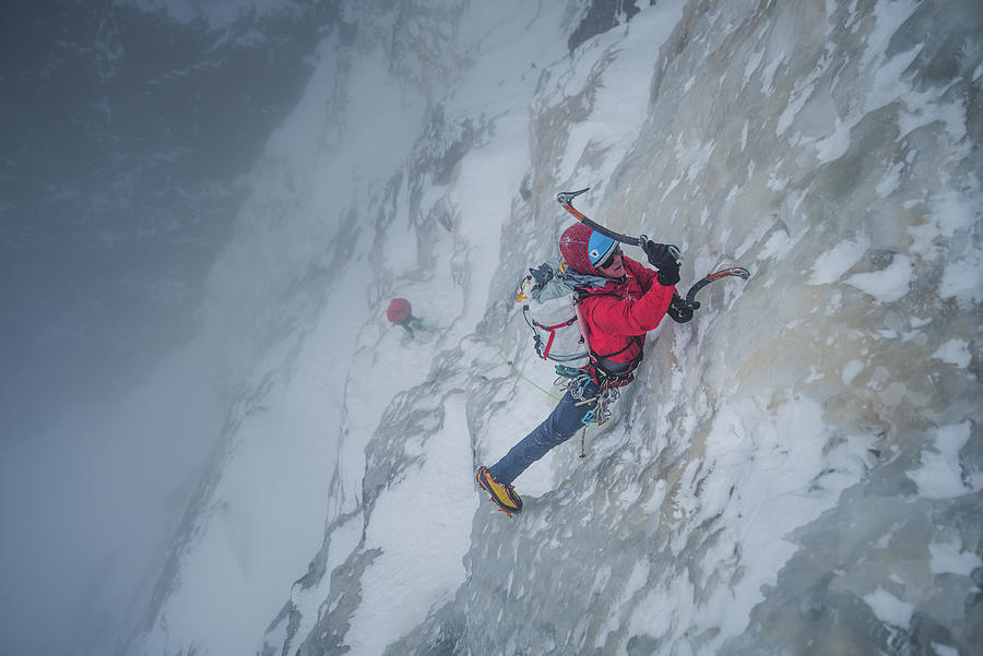 Ice Climber Climbing Steep Ice Wall With Rock Surrounding Him ...