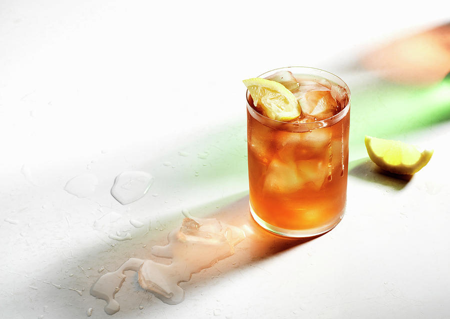 Ice Cold Iced Tea With Lemon Wedges, Drips On Glass, Colored Shadows And Melted Ice Photograph by Flashlight Studio