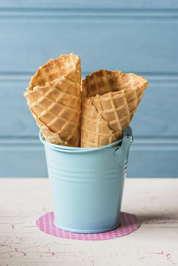 Ice Cream Cones In A Small Blue Enamel Bucket Photograph by Magdalena Hendey