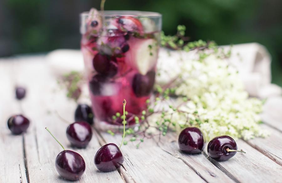 Ice Cubes With Cherries In A Glass Of Juice Photograph by Carolina Auer Photography
