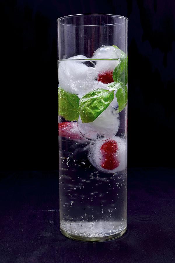 Ice Cubes With Raspberries And Basil In A Glass Of Water Photograph by Elli Briest