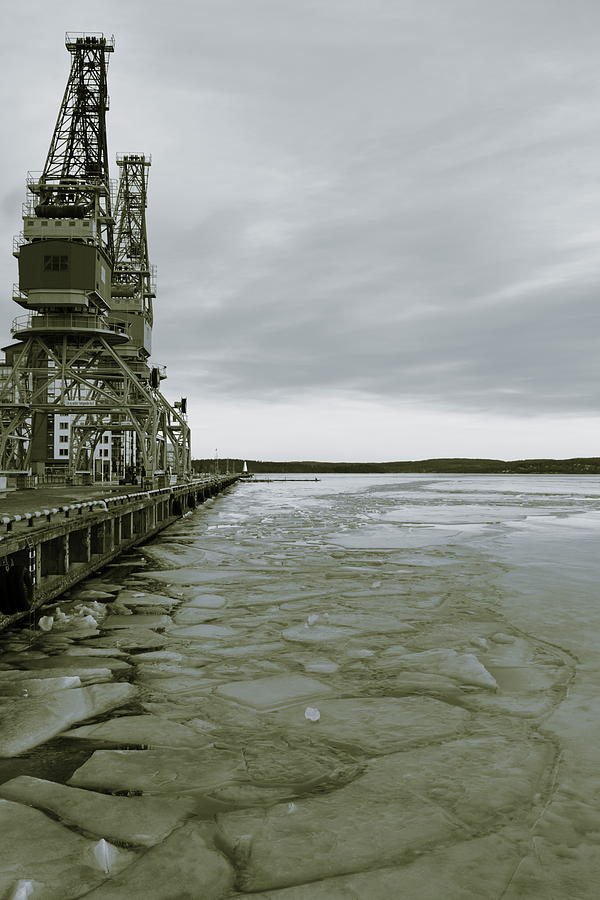Ice floes are floating on a harbor bay in winter - sepia Photograph by Intensivelight
