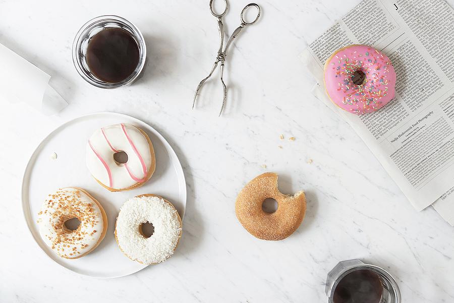 Iced Doughnuts And A Cinnamon-sugar Doughnut With A Bite Taken Out On A Marble Table Photograph by Nadja Hudovernik Food Photography