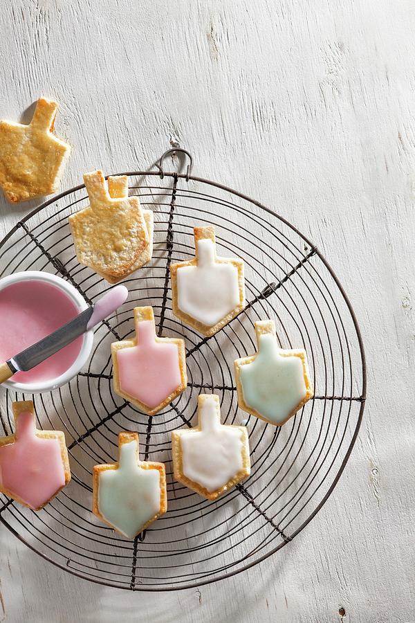 Iced Dreidel Biscuits On A Wire Rack Photograph by Danny Lerner