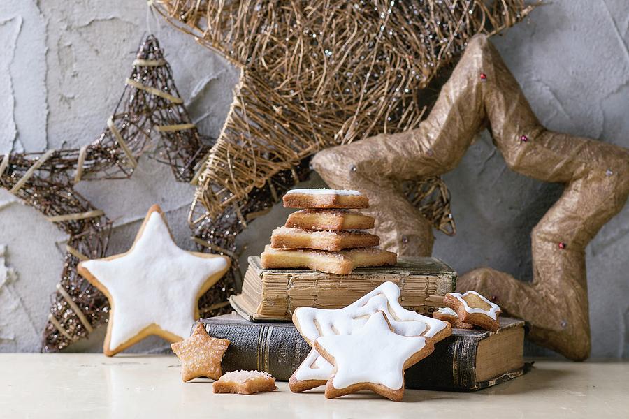 Iced, Star-shaped Christmas Cookies On Old Book With Christmas Decorations Photograph by Natasha Breen