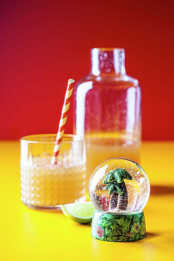 Iced Tea With Pineapple And Coconut Syrup In Front Of A Snow Globe With A Mini Palm Tree Photograph by Susan Brooks-dammann