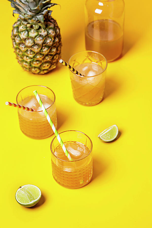 Iced Tea With Pineapple And Coconut Syrup In Glasses On A Yellow Background Photograph by Susan Brooks-dammann