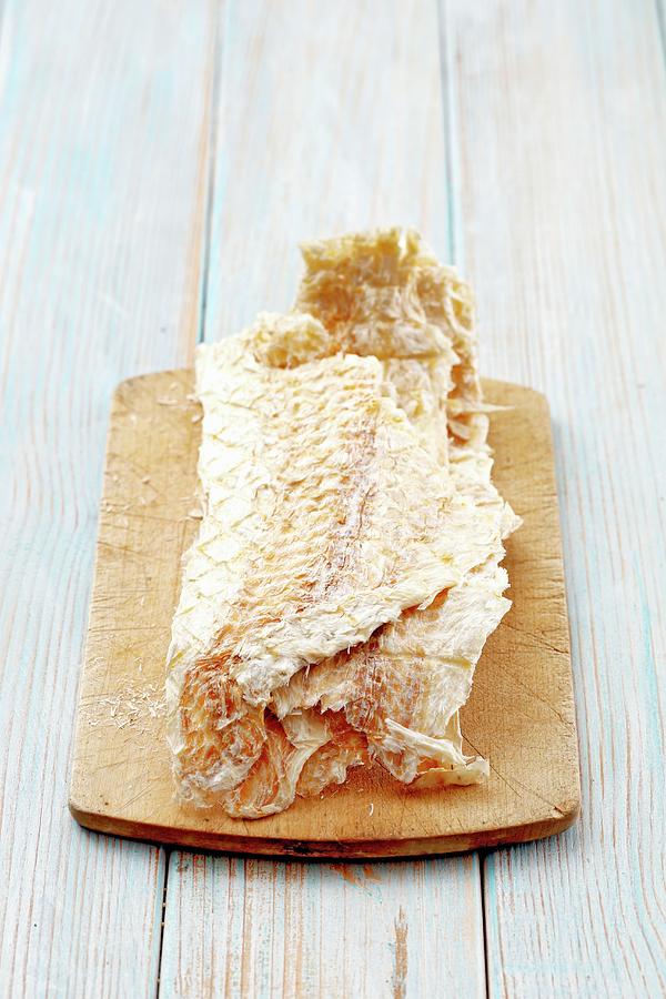 Fish Photograph - Icelandic Dried Fish On A Wooden Board by Petr Gross