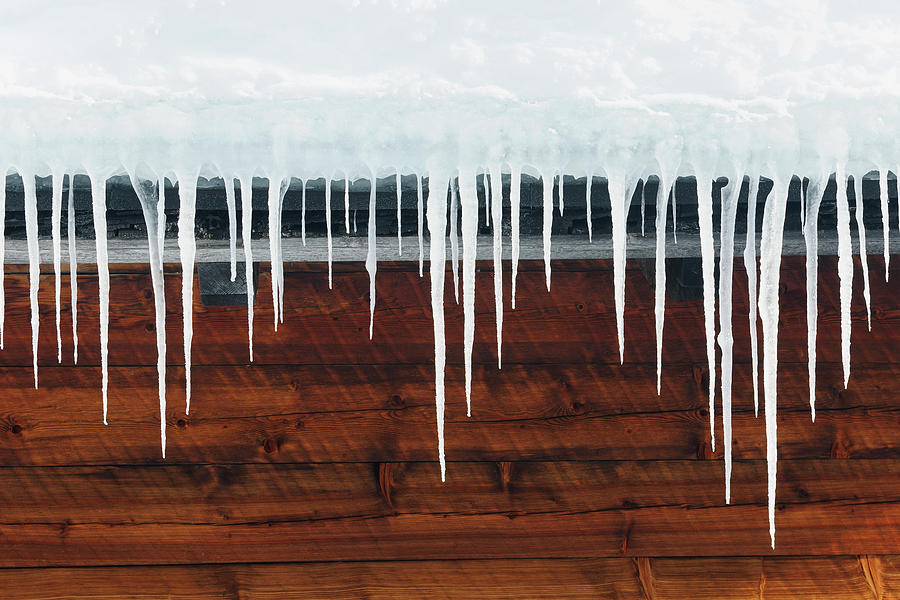 Icicles Hanging From A Roof Photograph by Cornelia Doerr