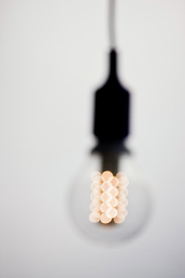 Illuminated Light Bulb, Defocused Photograph by Johner Images