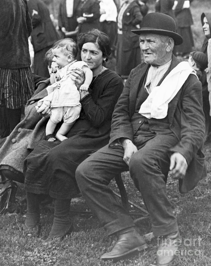 Immigrants Seated Outside Ellis Island Photograph by Bettmann