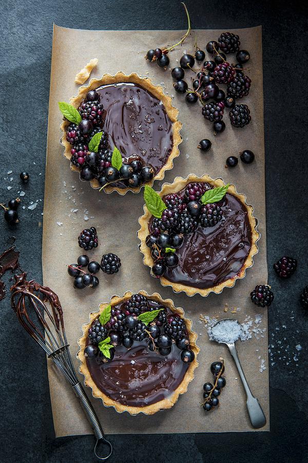 Individual Dark Chocolate And Sea Salt Tarts With Blackcurrants And Blackberries Photograph by Magdalena Hendey