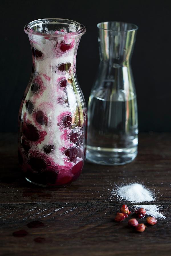 Ingredients For Cherry Liqueur alcohol, Sour Cherries, Sugar In A Carafe, Alcohol Being Added Photograph by Nicole Godt