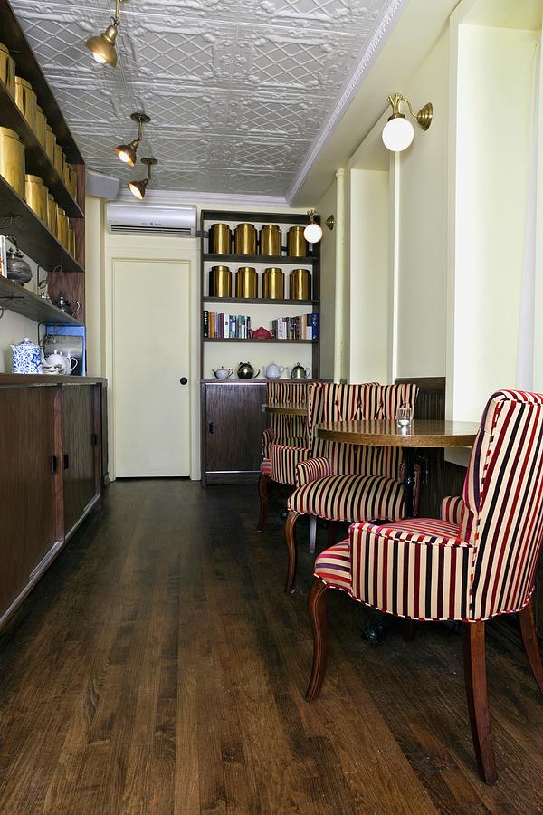 Interior Of Bosie Tea Cafe; Striped Chairs At Round Tables; Shelves With Tins Of Tea And Tea Pots Photograph by Amy Kalyn Sims