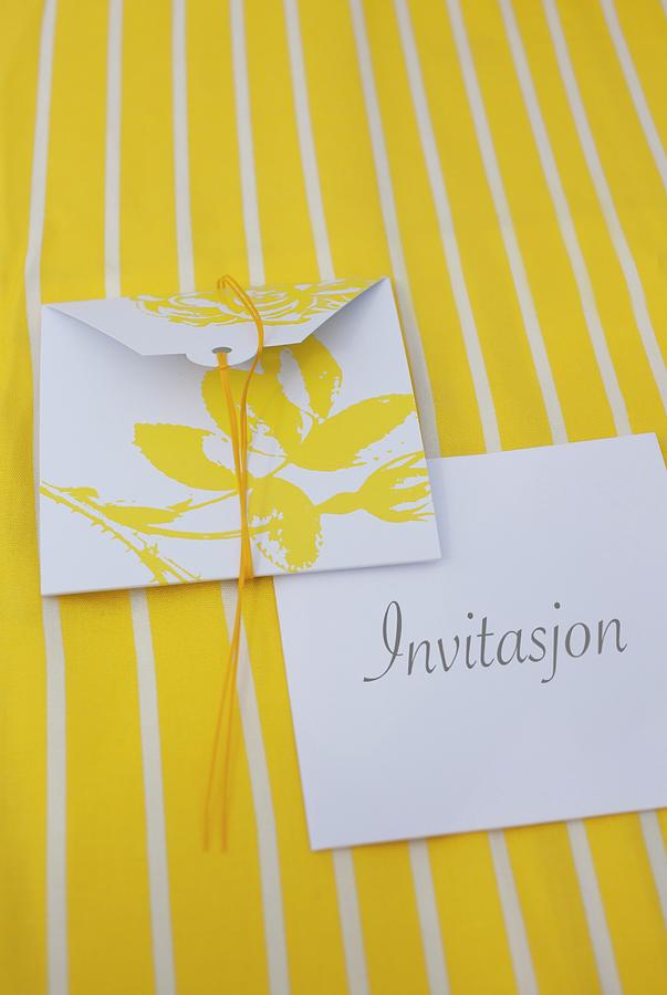 Invitation Cards With Yellow Floral Motif On White Envelope On Yellow And White Striped Surface Photograph by Annette Nordstrom