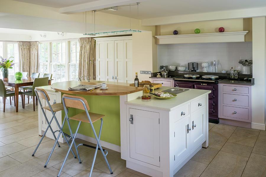 Island Counter And Classic Cupboard Doors In Various Colours In Open-plan Kitchen With Dining Area In Background Photograph by Brian Harrison