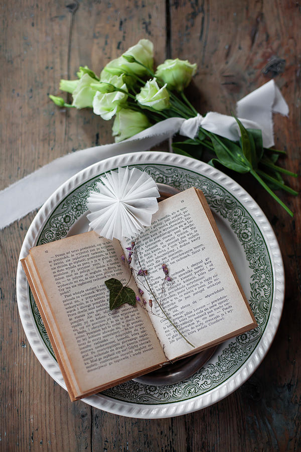 Ivy Leaf And Paper Rosette On Open Book Photograph by Alicja Koll