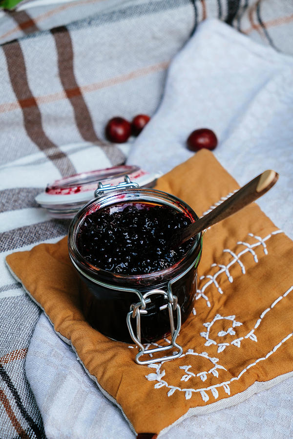 Jam In A Glass Jar On A Fabric Pillow Photograph by Lucie Beck