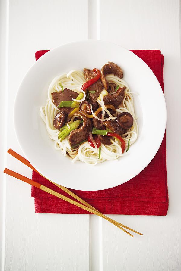 Japanese Dish Of Beef With Mushrooms And Spring Onions On A Bed Of Noodles Photograph by Michael Wissing