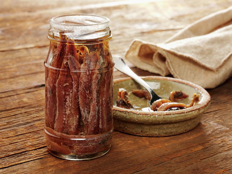 Jar Of Anchovies On Old Barnwood With A Few In Ceramic Dish With A Fork Photograph by Albert P Macdonald