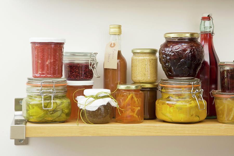 Jars And Bottles Of Preserves And Pickles On A Wooden Shelf Photograph by Joy Skipper Foodstyling