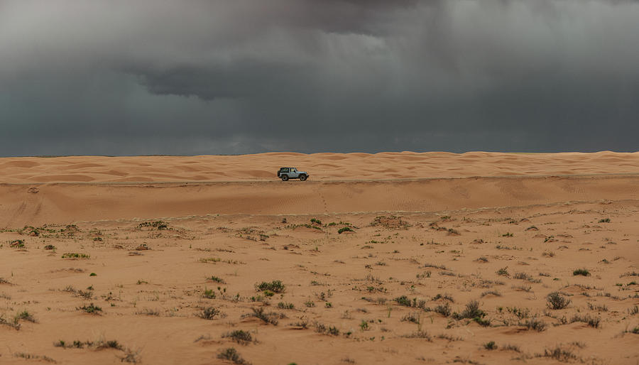 Jeep Drives Through The Sand Dunes Of Utah Under Stormy Skies ...