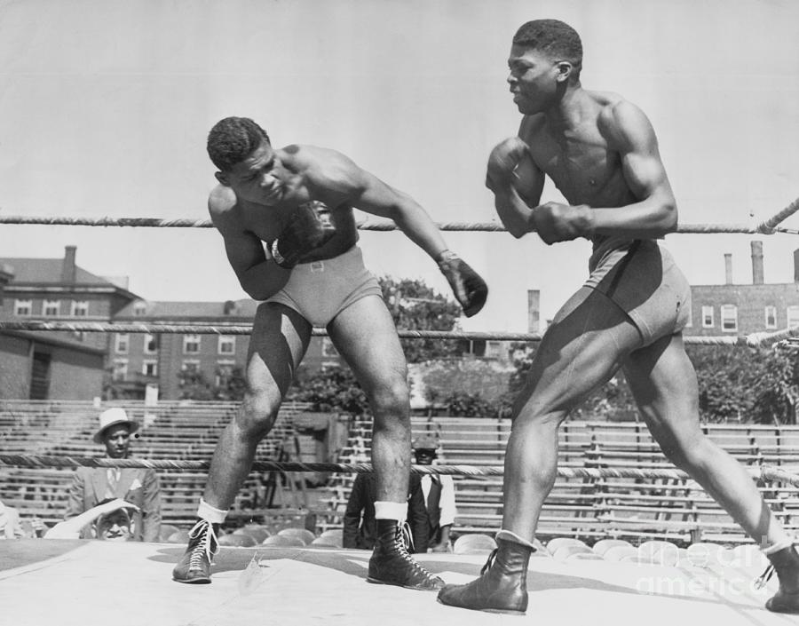 Joe Louis, Detroit heavyweight, shown sparring with Willie Davis of Chicago...