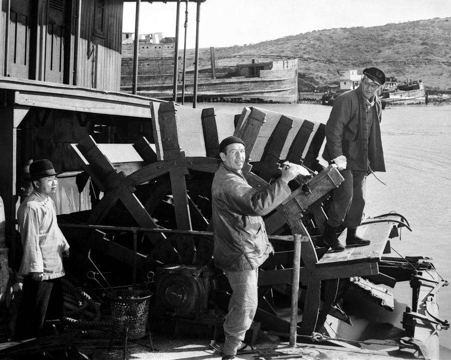 John Wayne And Mike Mazurki Turning Waterwheel Photograph by Globe ...