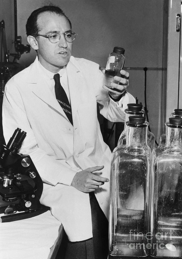 Jonas Salk Holding Bottle In Laboratory Photograph by Bettmann