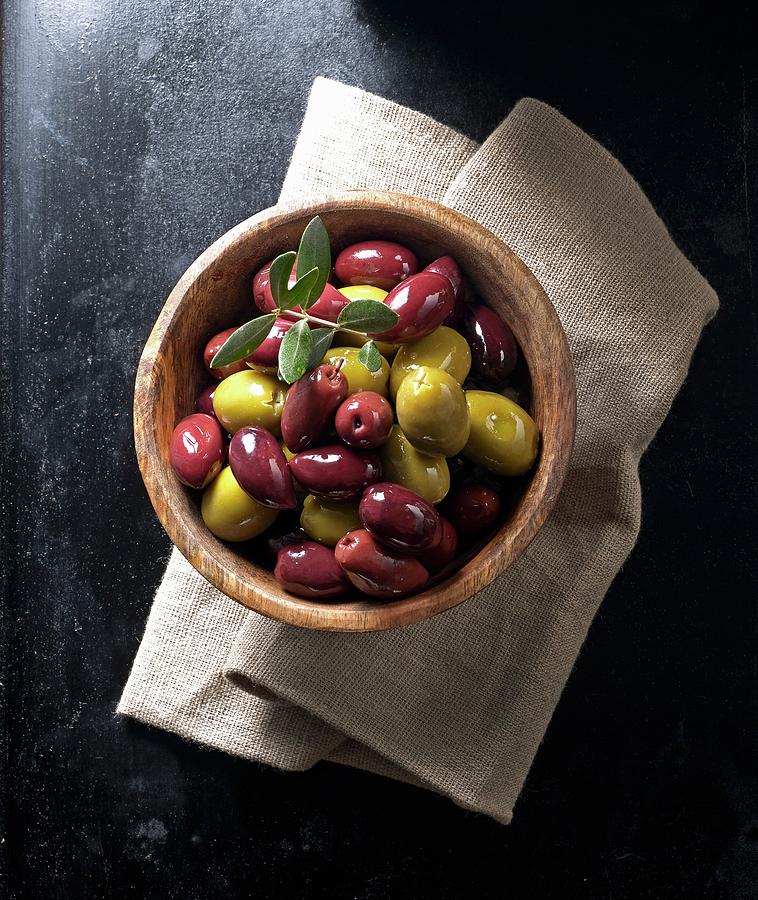 Kalamata Olives And Green Olives In A Wooden Bowl On A Linen Napkin Photograph by Ludger Rose