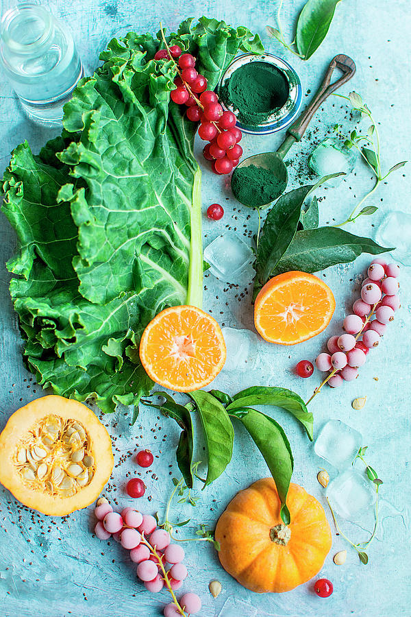 Kale, Pumpkin, Frozen Redcurrants, Oranges, Ice Cubes, Spirulina, Chia Seeds And Water Photograph by Olimpia Davies