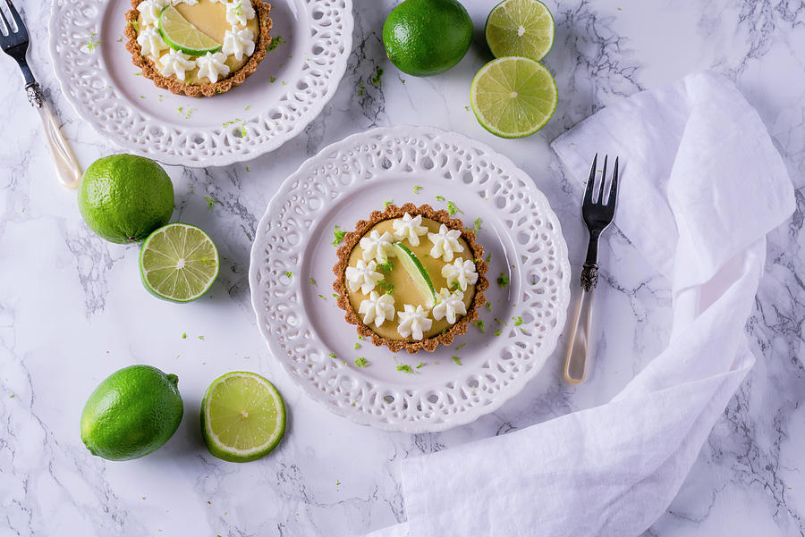 Key Lime Pie Tartlets With Cream Flowers Photograph by Christian Kutschka