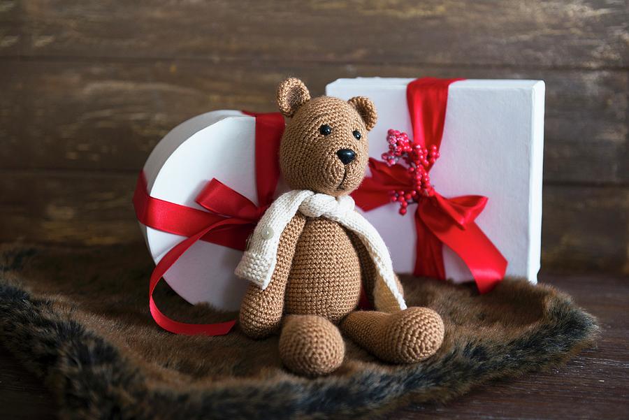 Knitted Teddy Bear In Front Of Christmas Presents Photograph by Veronika Studer