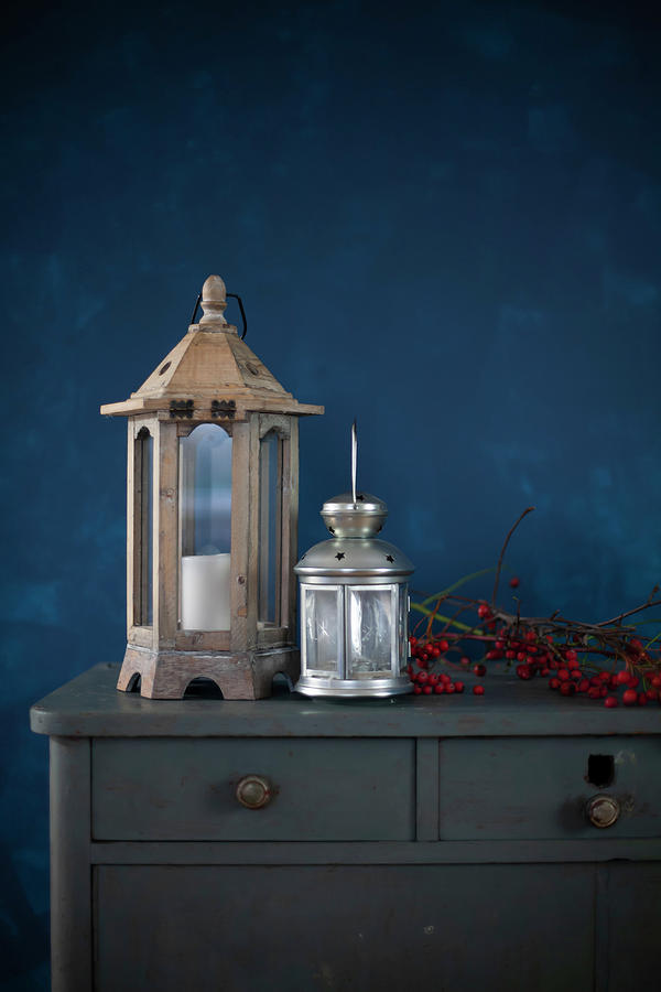 Lanterns And Branch Of Red Berries On Top Of Chest Of Drawers Photograph by Alicja Koll