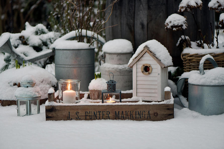 Lanterns And Nesting Boxes On A Snow-covered Wooden Box On A Terrace Photograph by Daniela Behr