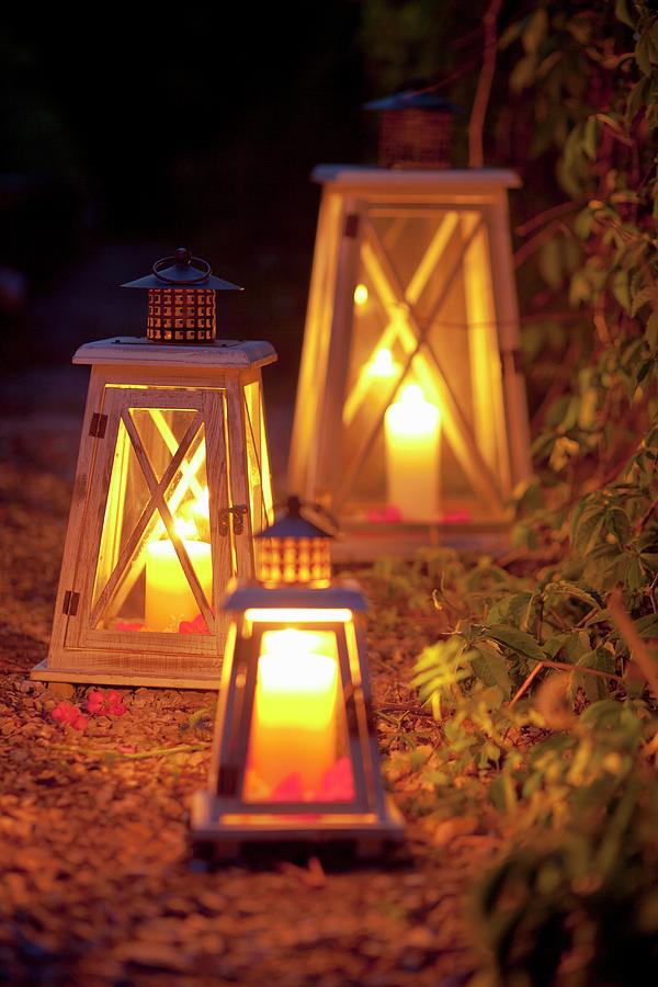 Lanterns With Candles Illuminating A Garden Path Photograph by Studio Lipov