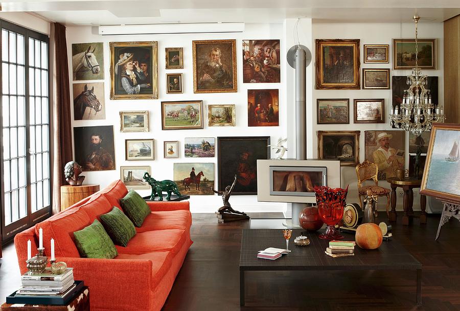 Large Gallery Of Oil Paintings In Living Room With Orange Couch, Antiques, Crystal Chandelier And Log Burner Photograph by Misha Vetter