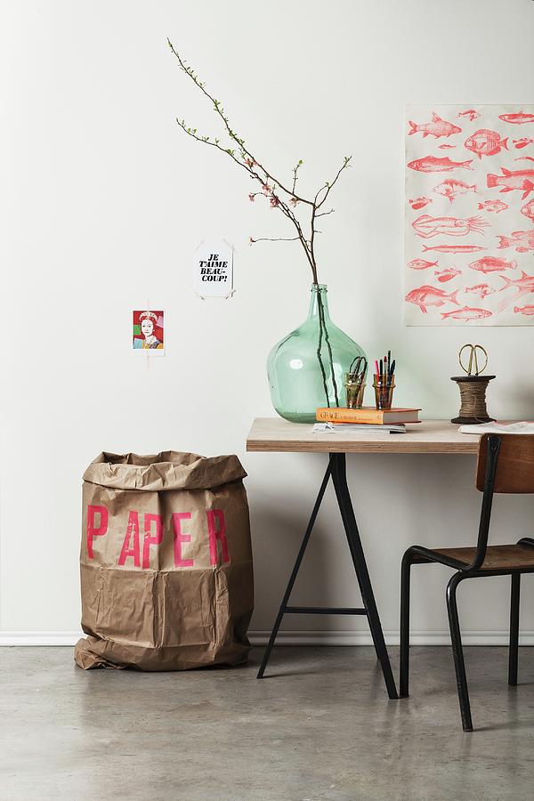Large Paper Rubbish Sack Printed With Red Letters Next To Writing Utensils And Flowering Branches In Demijohn On Desk Photograph by Michael Tasca