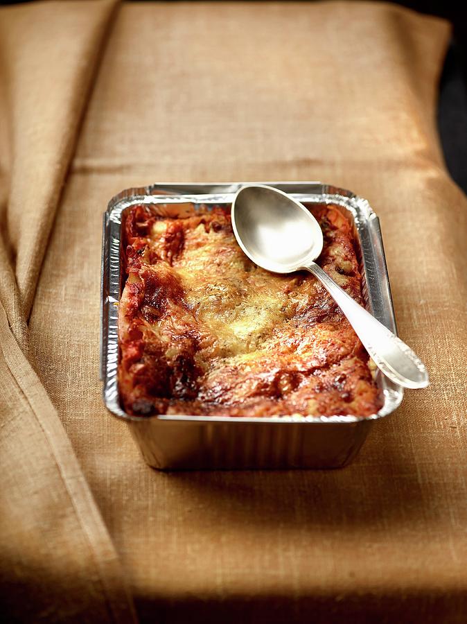 Lasagne With Tomatoes And Cheese In An Aluminium Tray With A Spoon Photograph by Frdric Perrin