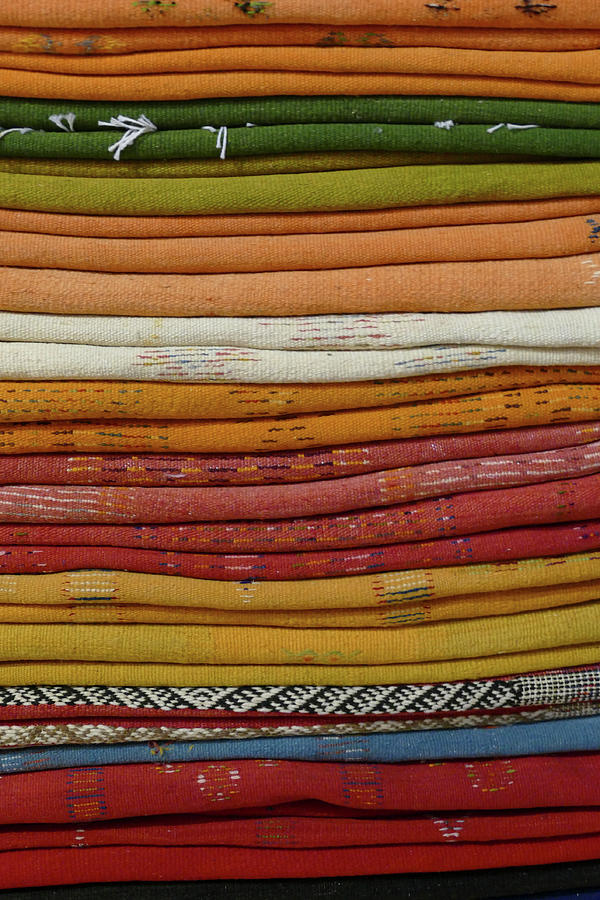 Layers of carpets in a shop in the medina Photograph by Steve Estvanik